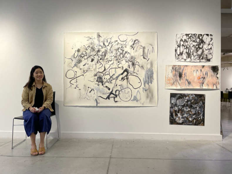 Artist Ara Ko with examples of her artwork
