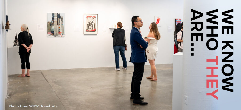 Photo of people visiting the 'We Know Who They Are...' exhibition, with the words 'We Know Who They Are...'superimposed over the photo. Photo is from the 'We Know Who They Are...' (WKWTA) website.