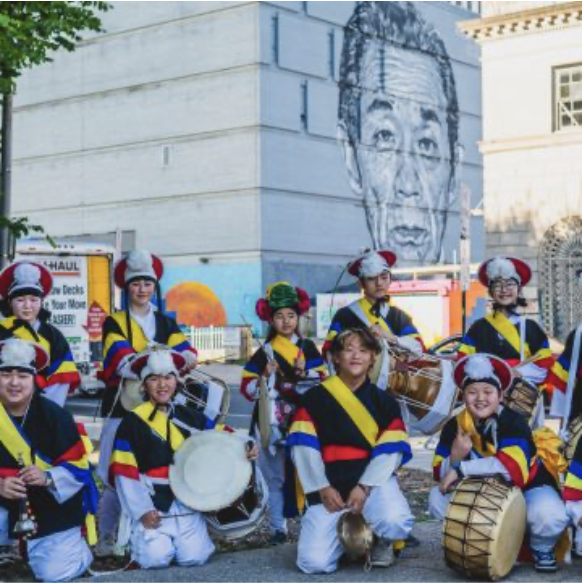 Korean samulnori performance infant of a mural of a Korean businessman in Baltimore's Station North arts district. 

